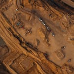 Aerial shot of an active mining site in England, showcasing natural deposits and excavation equipment.